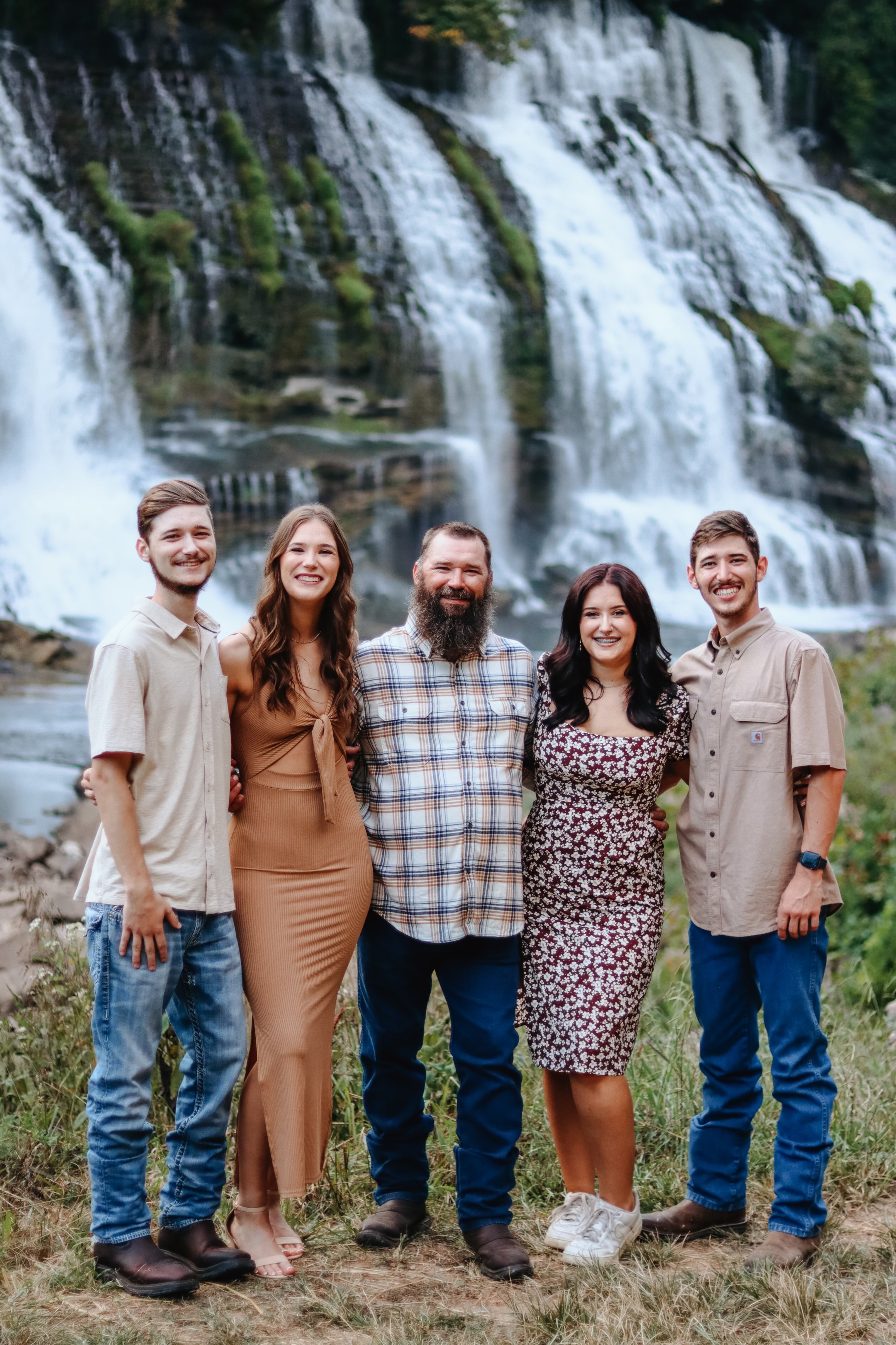 Carrie with her husband and children at a waterfall in Tennessee